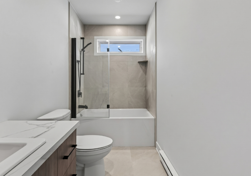 Salle de bain moderne avec douche vitrée d’un condo locatif à Valleyfield
